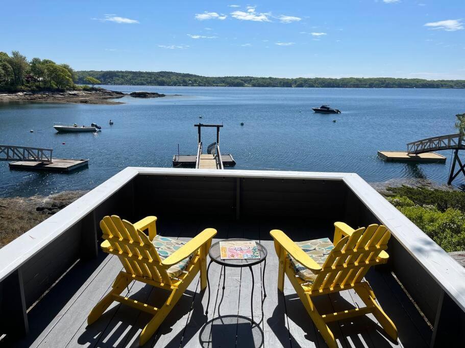 2 sedie e un tavolo su una terrazza con vista sul lago di Compass Rose a Boothbay Harbor