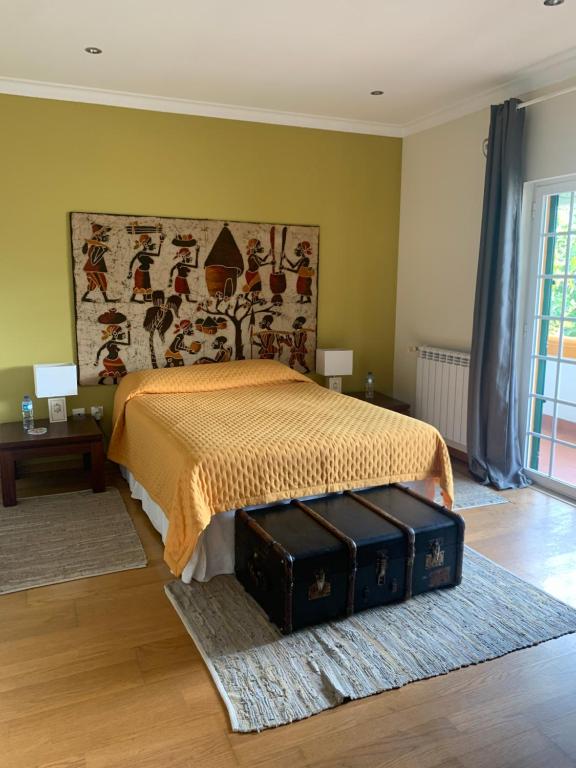 a bedroom with a bed with two suitcases on the floor at A Casa do Lagar in Azeitao