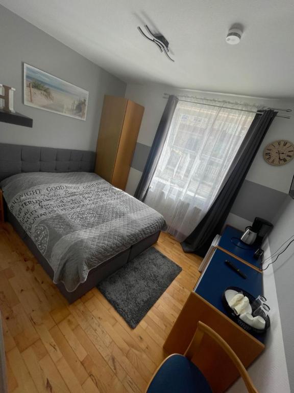 a small bedroom with a bed and a window at Pension Stral-Sund UG in Stralsund