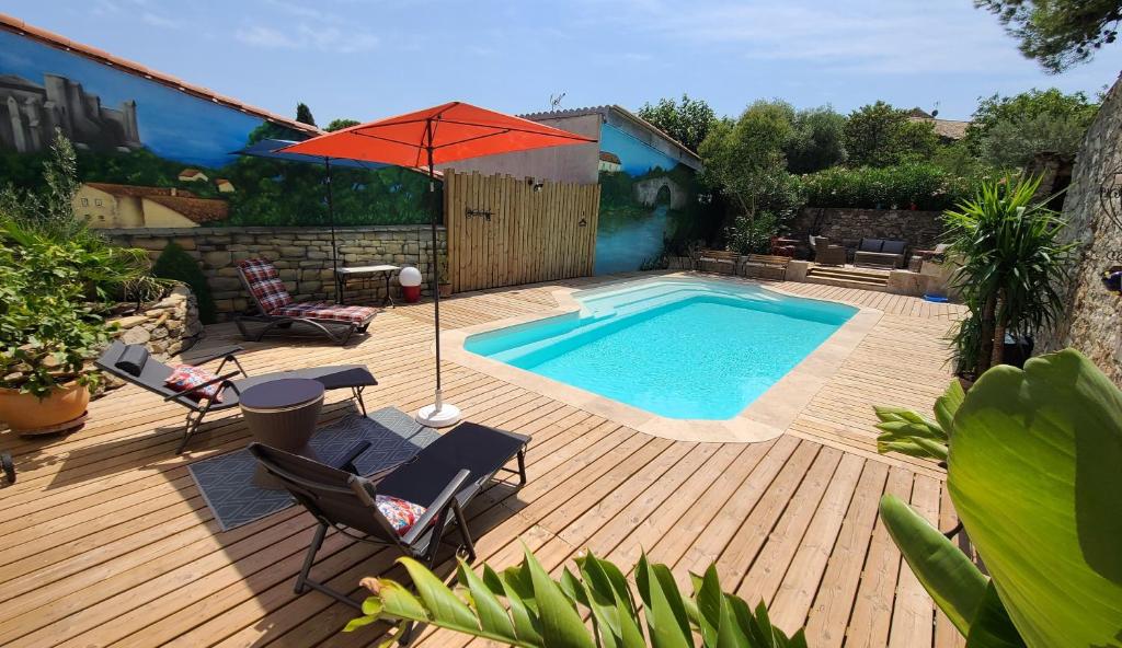 a patio with a swimming pool and an umbrella at Le N 9 in Argeliers