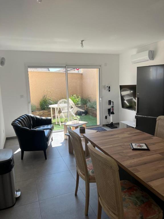 une cuisine et un salon avec une table et des chaises dans l'établissement Maison10 avec 1 chambre lechaffardcom, à Satolas-et-Bonce