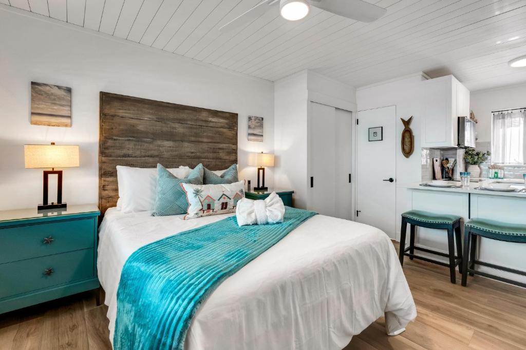 ein Schlafzimmer mit einem großen Bett mit einer blauen Decke in der Unterkunft Tropic Terrace Suite #39 - Beachfront Resort in St Pete Beach