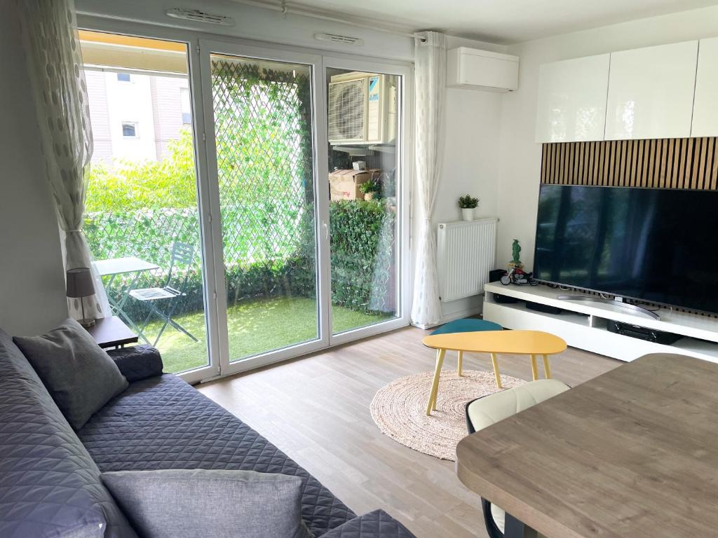 un salon avec un canapé, une télévision et une table dans l'établissement Splendid modern Duplex with 4 bedrooms, very close to Paris, metro 