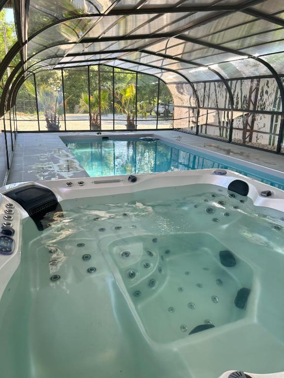 - un bain à remous dans un bâtiment avec une piscine dans l'établissement Le Domaine du Lavoir en privatisation, à Villemoiron-en-Othe