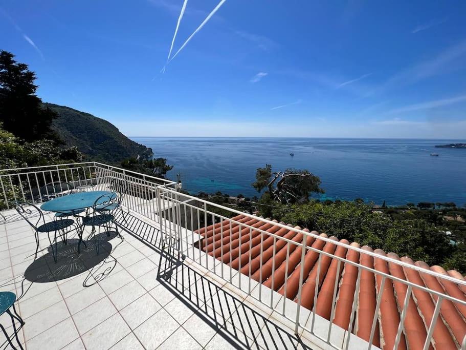 un balcon avec une table et des chaises et l'océan dans l'établissement Entre les citronniers et la mer, à Èze
