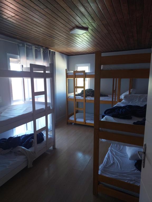 um quarto com três beliches e uma janela em Hostel Papai em Florianópolis