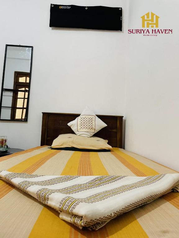 a bed with a blanket on top of it at Suriya Haven Homestay in Badulla