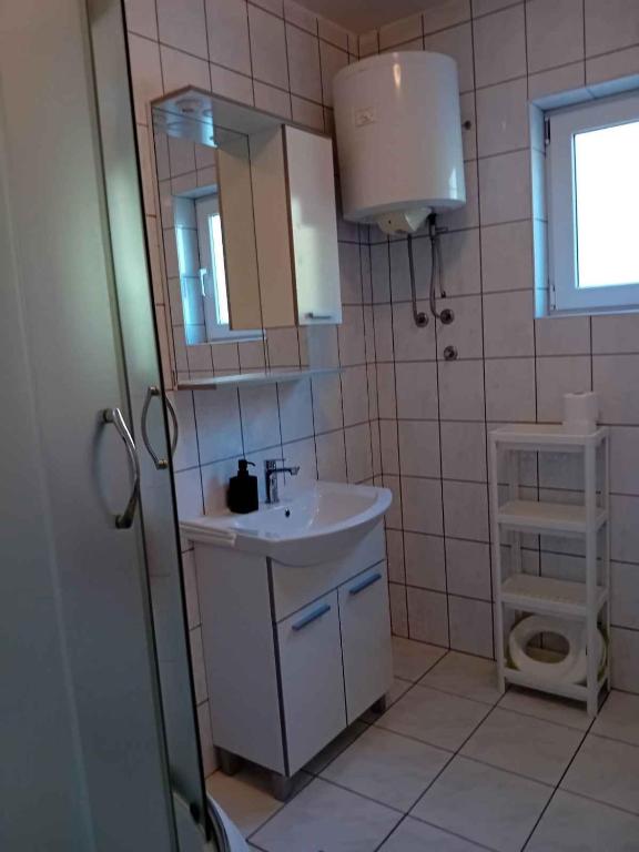 łazienka z umywalką, lustrem i toaletą w obiekcie Apartments in Klimno - Insel Krk 12514 w mieście Klimno