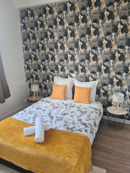 a bedroom with a bed with a wall with birds on it at Le Saint-Saturnin in Blois