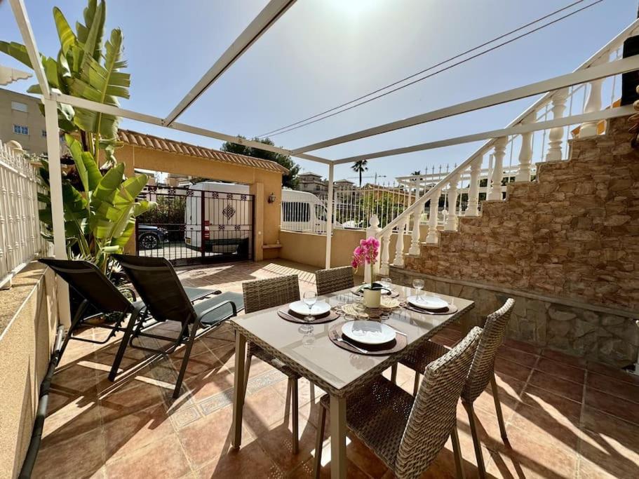 a patio with a table and chairs on a balcony at House in Orihuela Costa La Zenia in Orihuela