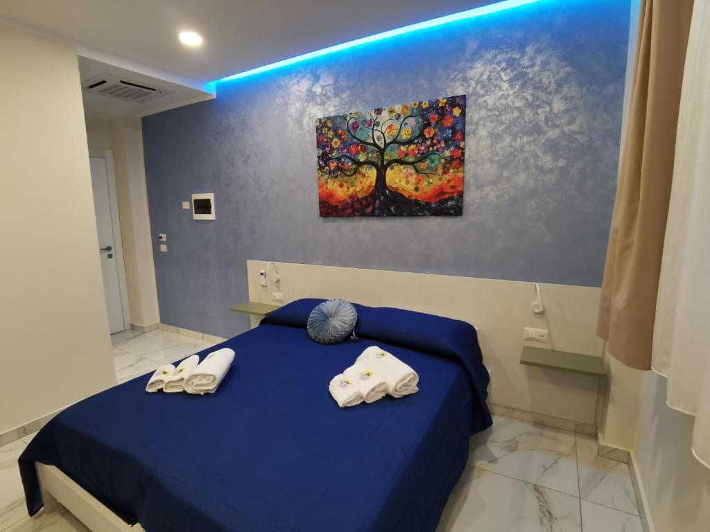 a bedroom with a blue bed with two towels at B&B AIDA Rooms Cefalù in Cefalù