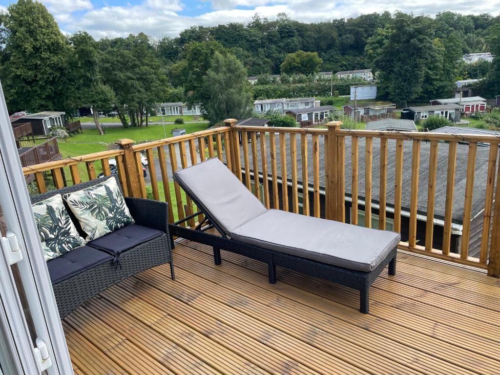 a balcony with a chair and a bench on a deck at Moonlight Lodge in Caeathro