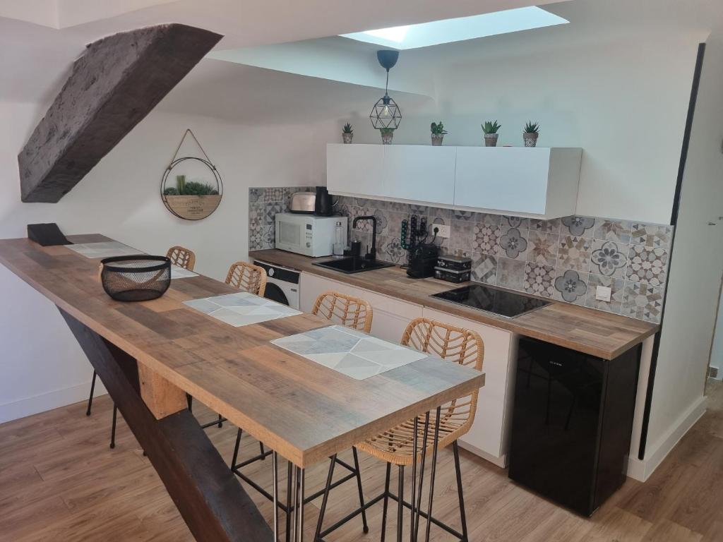 une cuisine avec une table en bois et quelques chaises dans l'établissement Le Palais Longchamp Marseille, à Marseille