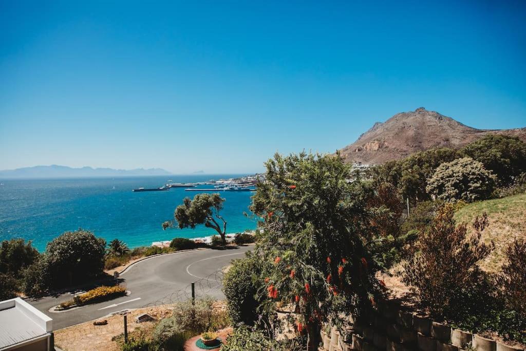a road on the side of a hill next to the ocean at Baydream Away in Cape Town