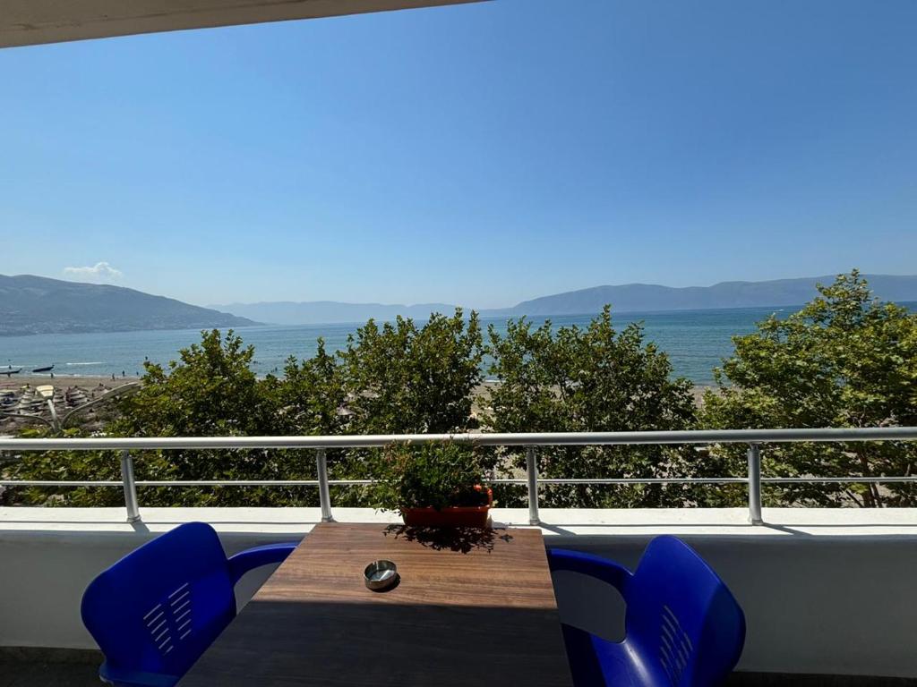 a table and chairs on a balcony with a view of the ocean at Grace Beachfront Apartment Vlore in Vlorë