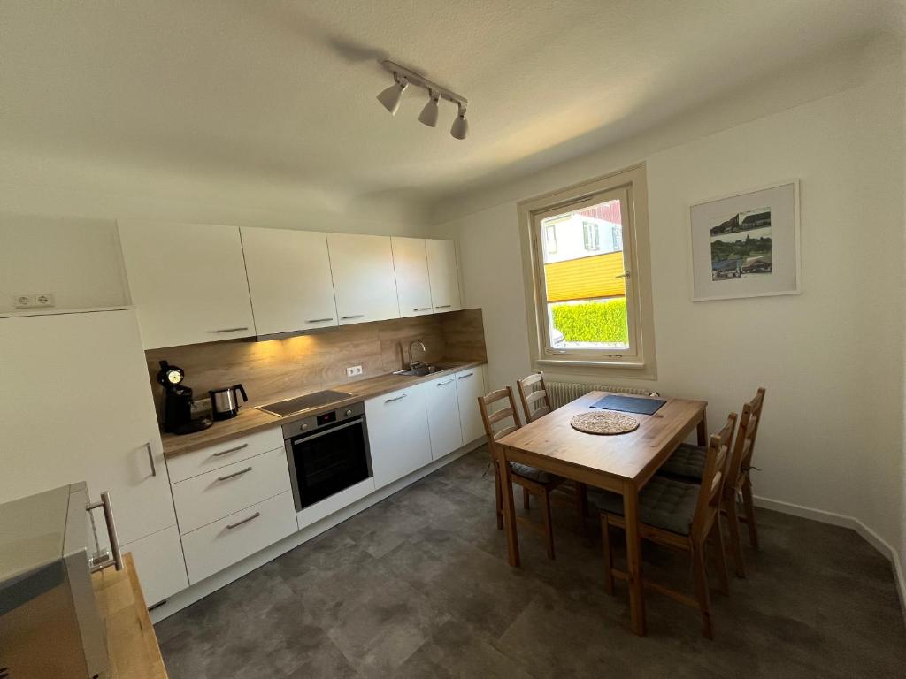 a kitchen with a wooden table and a dining room at Haus Anna in Freudenstadt