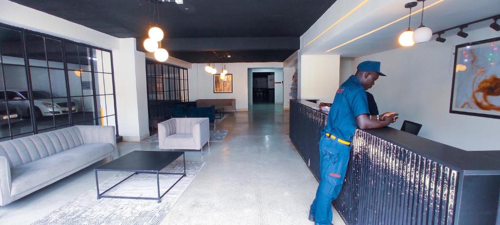 a man standing at a counter in a living room at Serene Hills Home in Nairobi