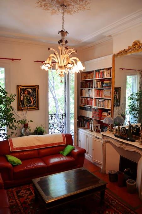 - un salon avec un canapé rouge et un lustre dans l'établissement Grand T5 bourgeois Canebiere, à Marseille