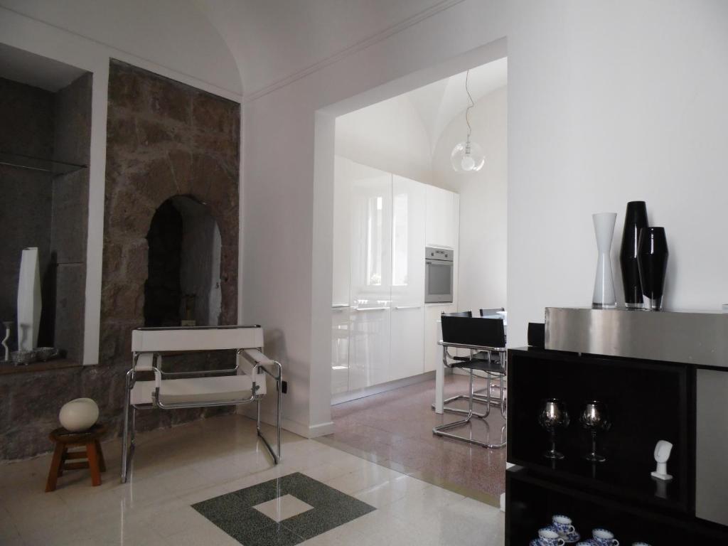 a white kitchen with a table and chairs in it at Around the Medieval Tower in Viterbo
