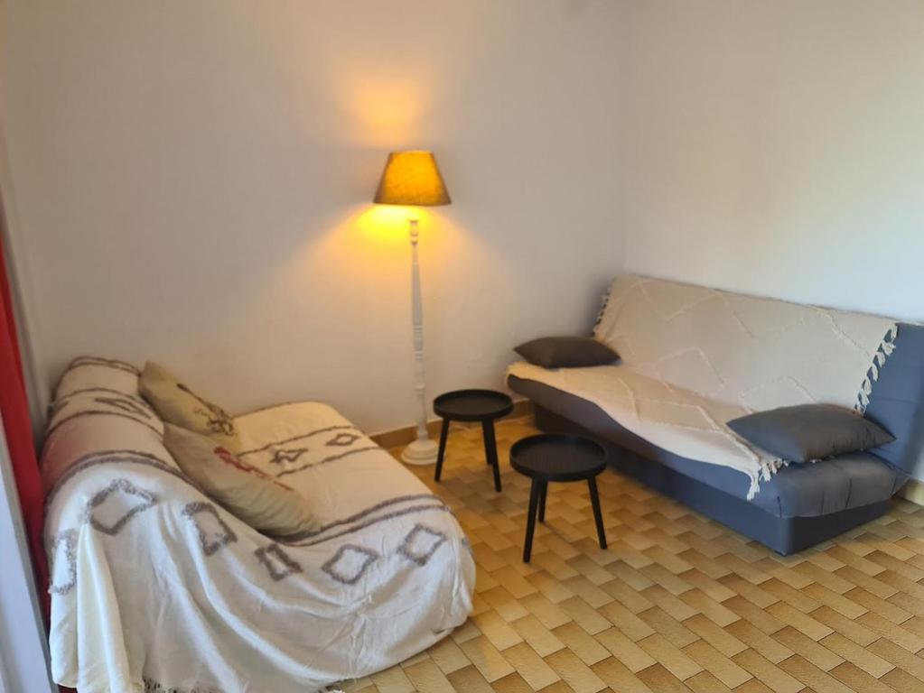 - un salon avec un canapé et deux tabourets dans l'établissement Très beau studio cabine, au Cap d'Agde