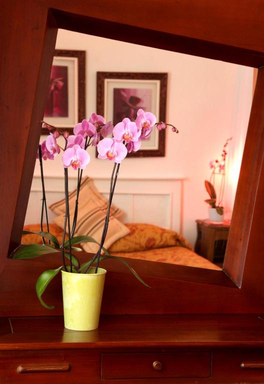 a vase of flowers sitting on a table in front of a mirror at Chez Madame Cailleau in Houlgate