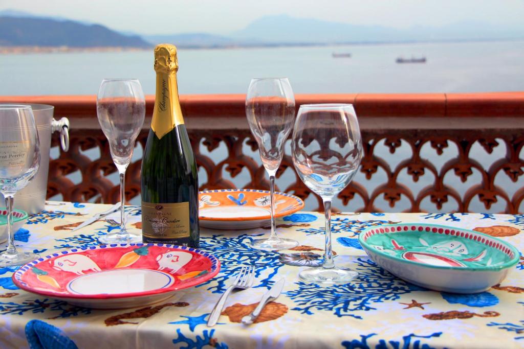 un tavolo con bicchieri e una bottiglia di vino di VILLA FUENTI BAY -Amalfi Coast- a Cetara