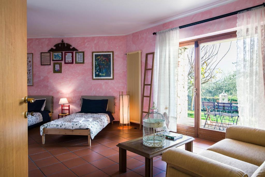 a living room with a bed and a couch and a table at B&B Casa Degli Ulivi in Negrar