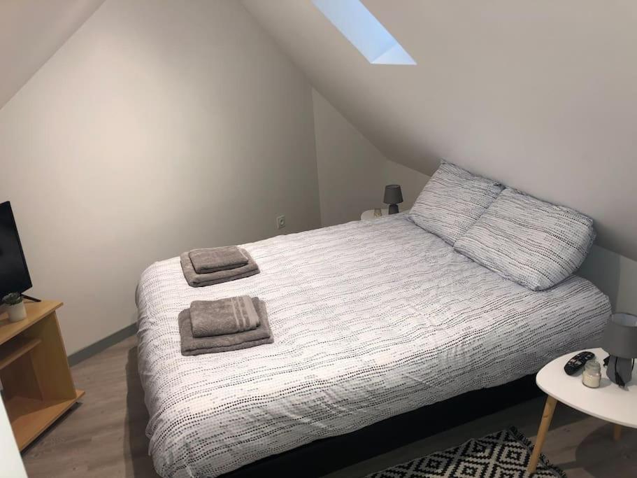 une chambre avec un lit avec deux serviettes dessus dans l'établissement Appart Sara-Dieppe, La Perle, à Neuville-lès-Dieppe