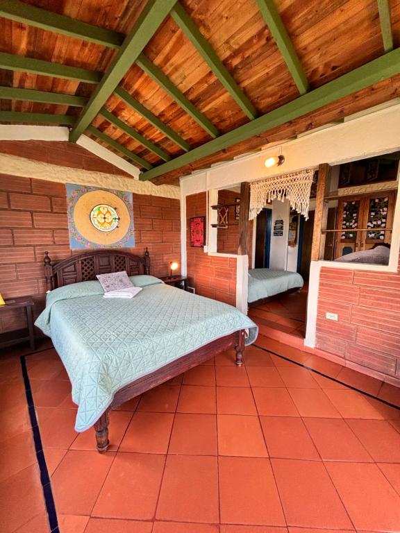 a bedroom with a bed and a wooden ceiling at Casa Encuentro Ecolodge, Outdoor Gym and Yoga in Guatapé