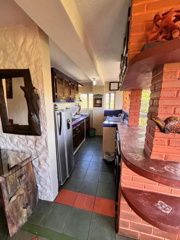 a kitchen with a counter top and a refrigerator at Casa Encuentro Ecolodge, Outdoor Gym and Yoga in Guatapé
