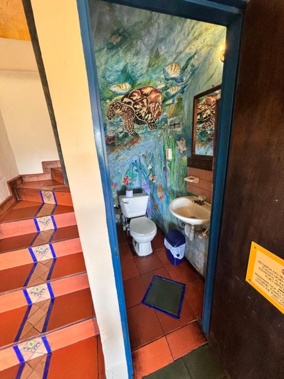 a bathroom with a painting on the wall at Casa Encuentro Ecolodge, Outdoor Gym and Yoga in Guatapé
