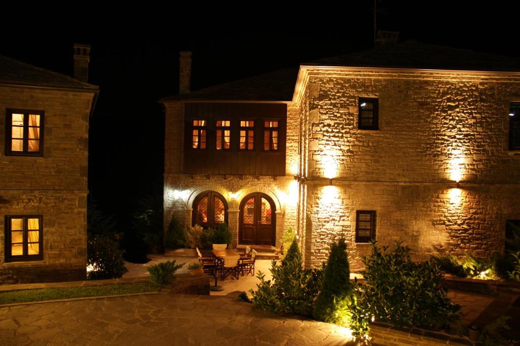 een groot stenen gebouw met 's nachts verlichting bij Adrasteia Guesthouse in Negádes