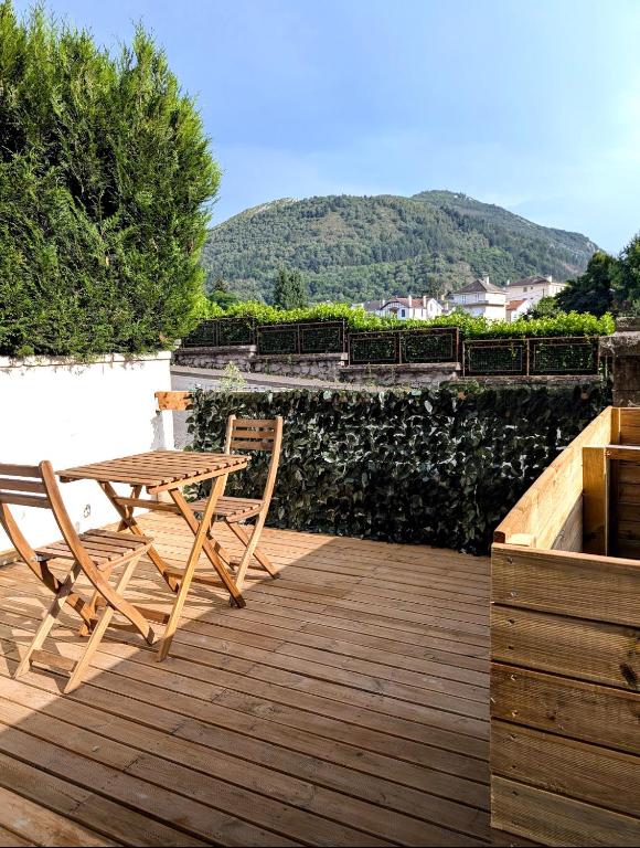 une terrasse en bois avec une table et des chaises dessus dans l'établissement Atypique Studio avec terrasse, à Lourdes