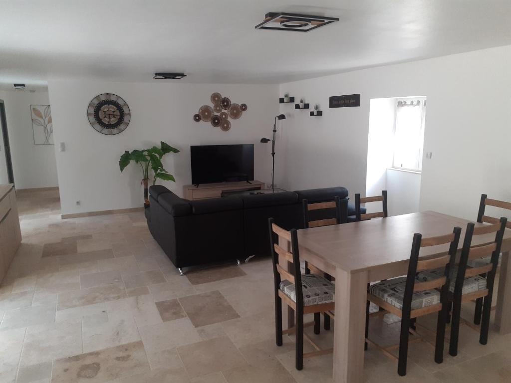 un salon avec une table et un canapé dans l'établissement Maison dans le Périgord, à Saint-Cernin-de-lʼHerm