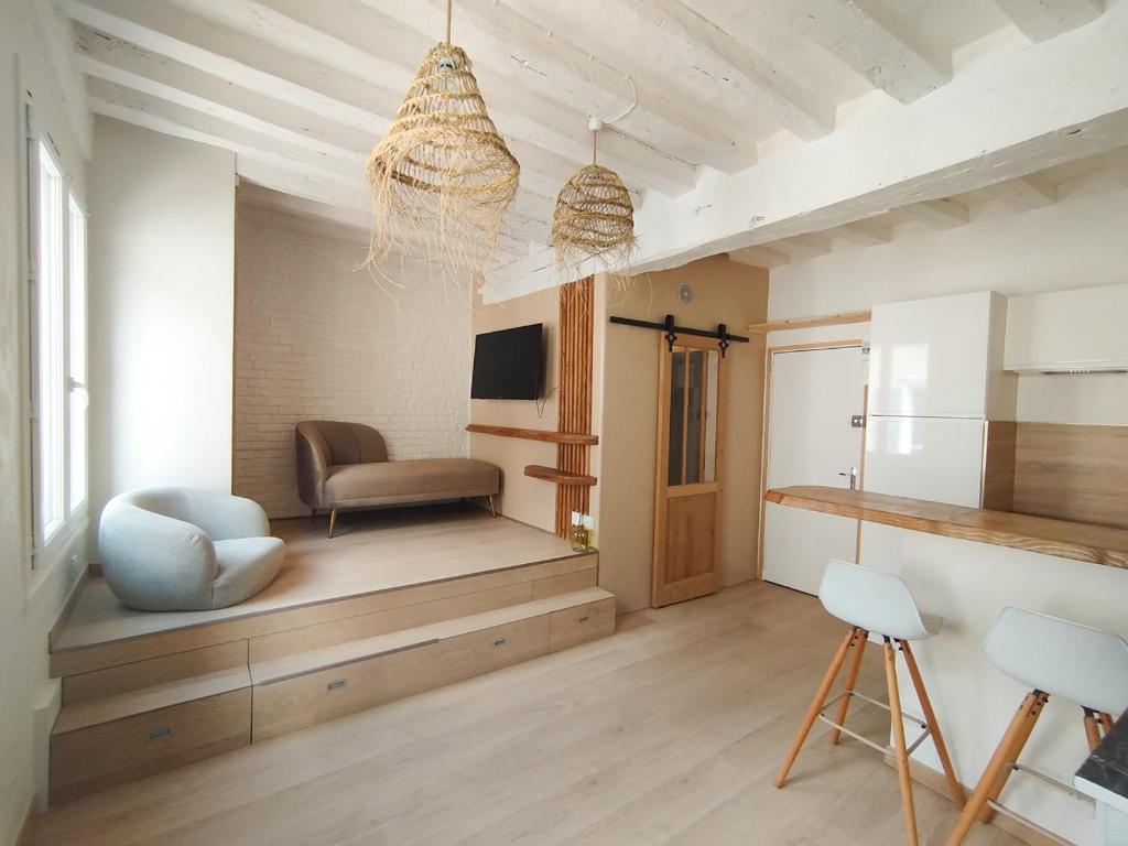 un salon avec une chaise et une télévision dans l'établissement Studio Harmoni - Centre ville à pied, à Chartres