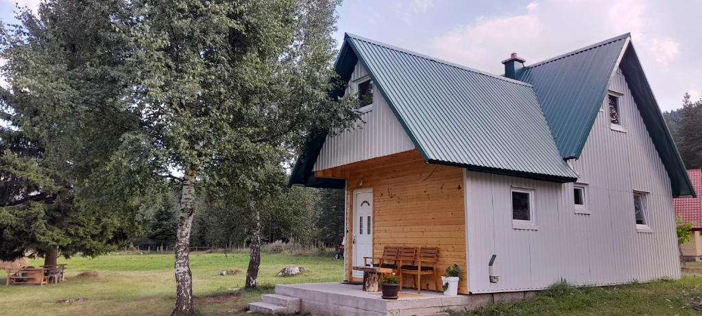 a large white building with a gambrel roof at Holiday Home Krejović in Žabljak