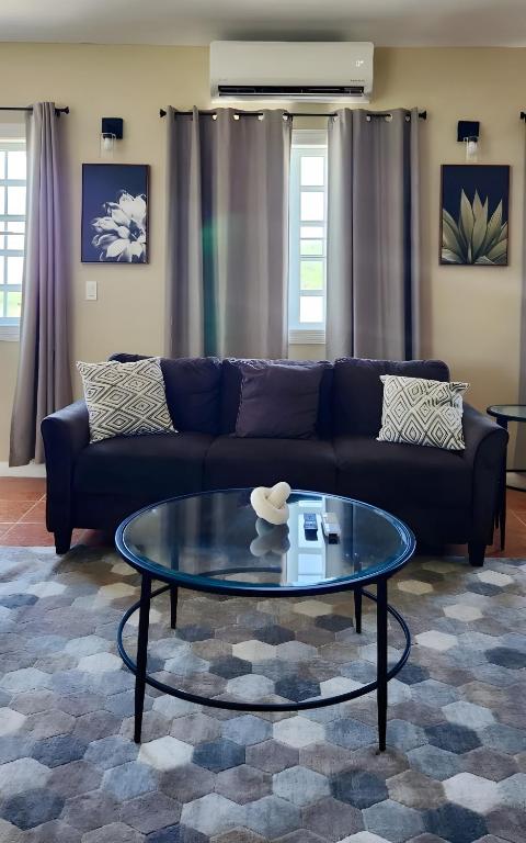 a living room with a blue couch and a glass table at Experience Cruzan Comfort in Christiansted