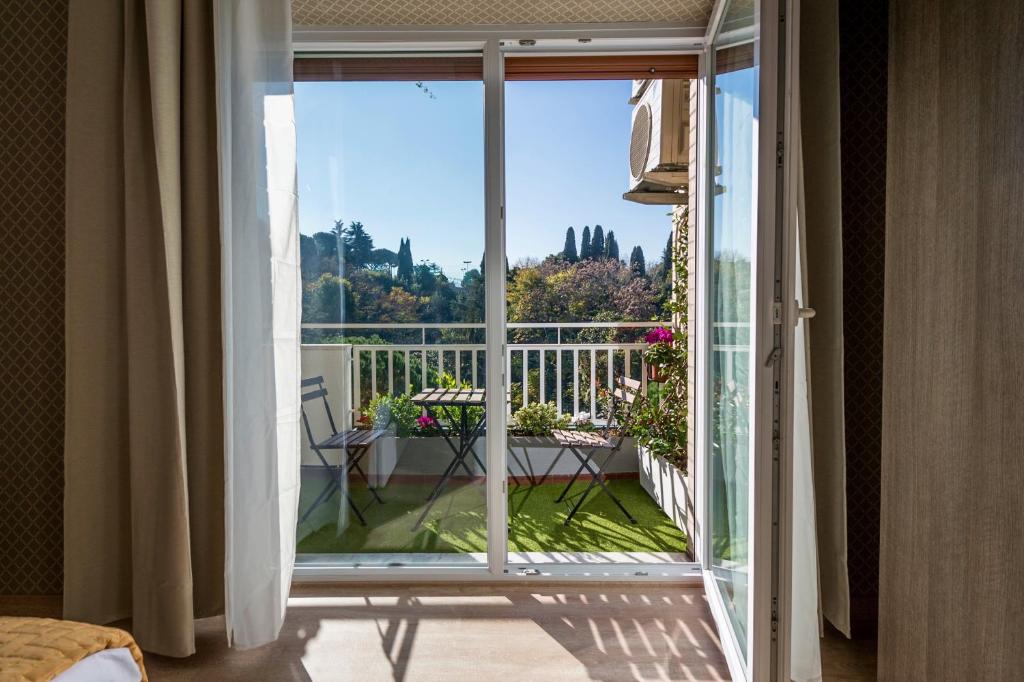 Habitación con una puerta corredera de cristal que da a un balcón. en Happy Holiday in Rome b&b, en Roma