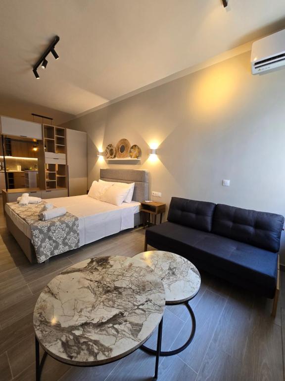 Un dormitorio con una cama, un sofá y una mesa. en Órrhaon Athens, en Atenas