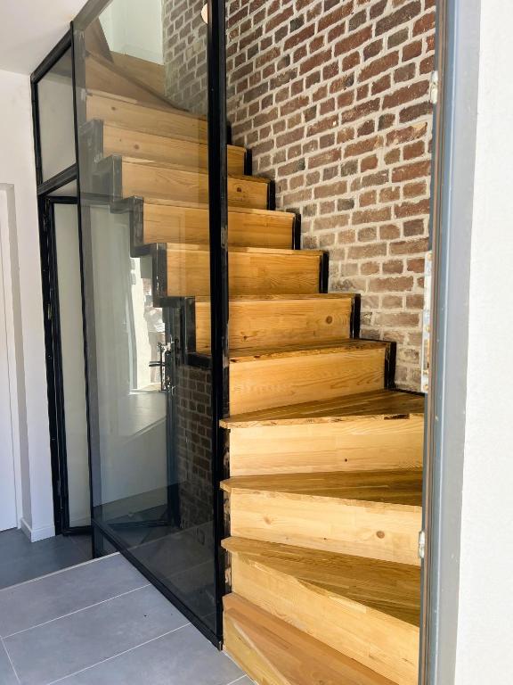 un escalier en bois avec une paroi en verre dans l'établissement villa Konny studio 1er étage, au Tréport