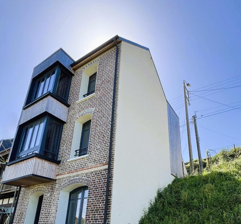 ein hohes Backsteingebäude mit Fenstern auf einem Hügel in der Unterkunft villa Konny studio 1er étage in Le Tréport