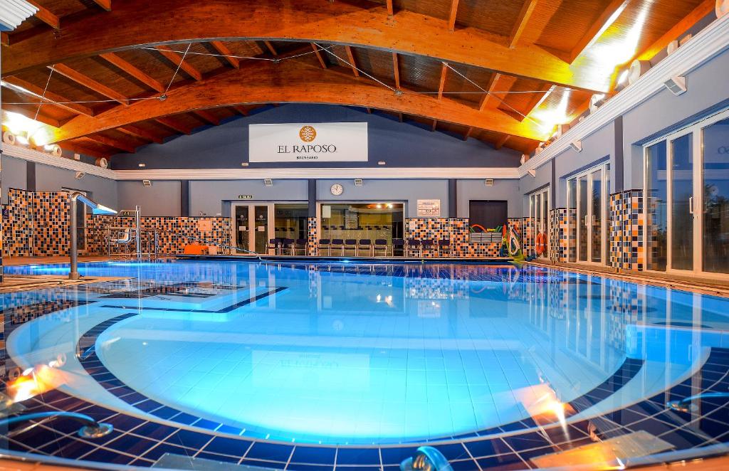 a large swimming pool in a hotel lobby at Hotel Balneario El Raposo in Puebla de Sancho Pérez