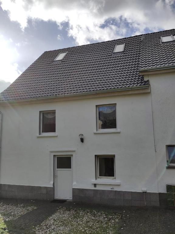 a white house with a black roof at Ferienhaus Salmtal Himmerod in Großlittgen