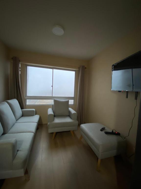 a living room with a white couch and a window at Entire Apartment 20 min from airport - Cozy and Secure in Lima