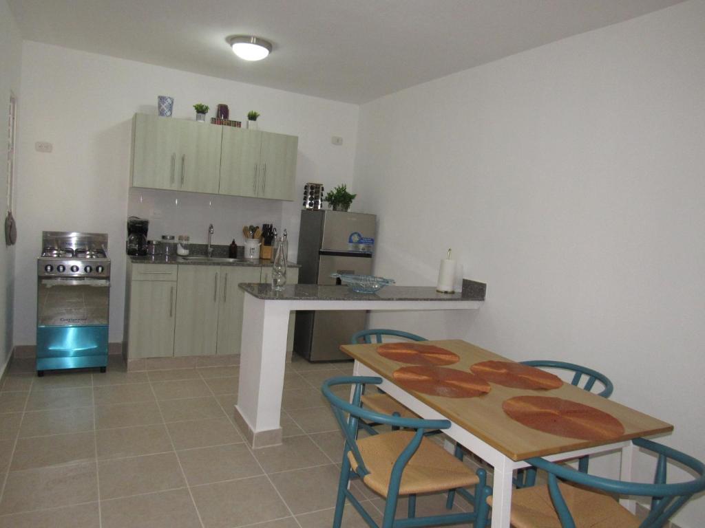 a kitchen with a table and chairs and a kitchen with a stove at Apartamento Acogedor en Santo Domingo Este Ciudad Juan Bosh in La Javilla