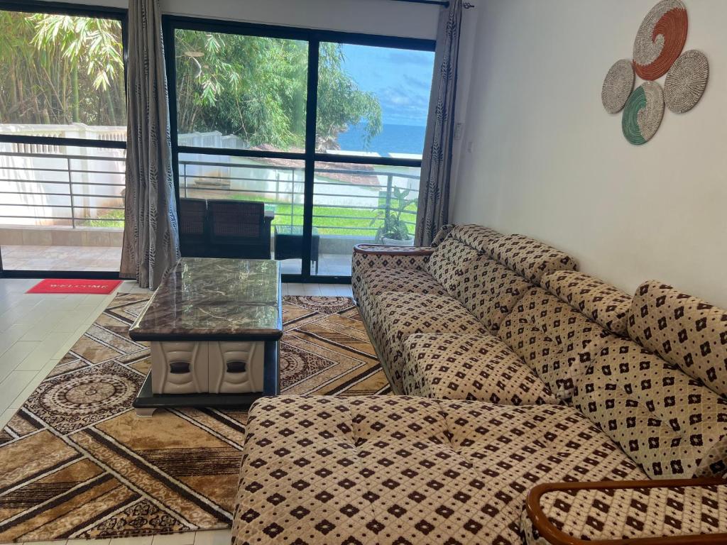 a living room with a couch and a table at Relax Oceanfront Suites in Sere Kunda