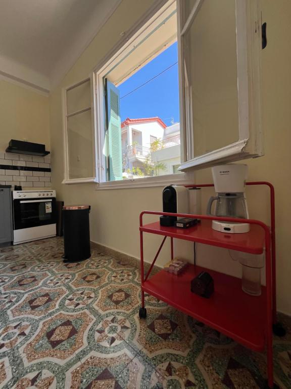 a kitchen with a red table and a window at Αλμα - A Family boutique apartment at the city center in Kalamata