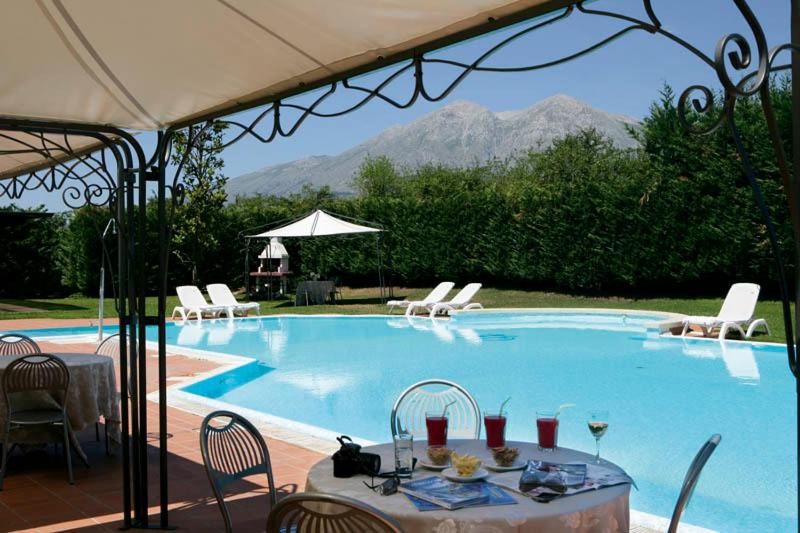 une piscine avec des chaises et une table, ainsi qu'un tableastryasteryasteryastery astery dans l'établissement Hotel Olimpia, à Avezzano