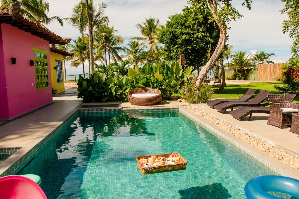 a swimming pool with a tray in the middle of a house at Pousada Villa Tainá - Arraial d'Ajuda, Bahia in Arraial d'Ajuda