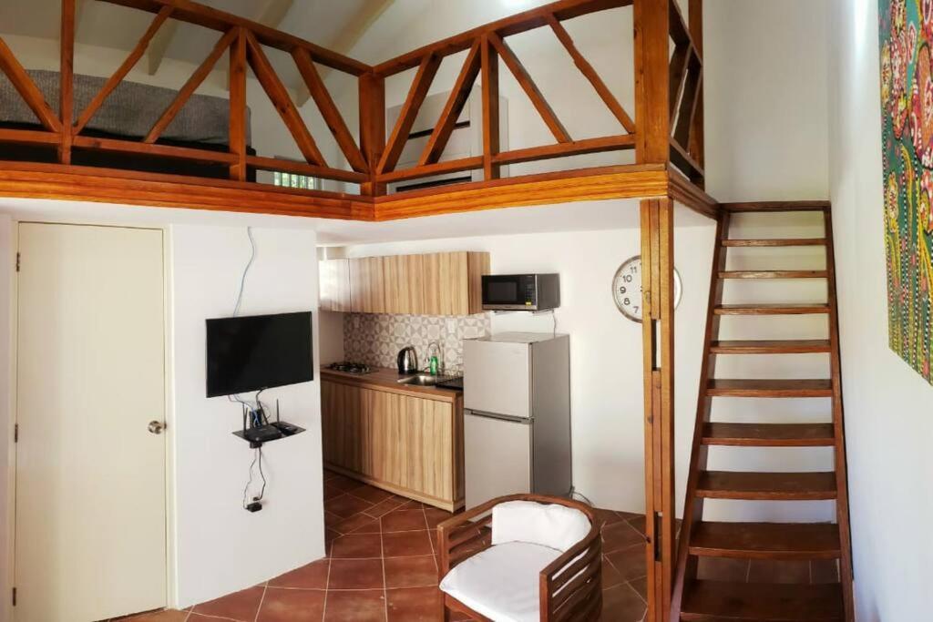 una camera con scala e una cucina con frigorifero di Cozy apartment a Willemstad